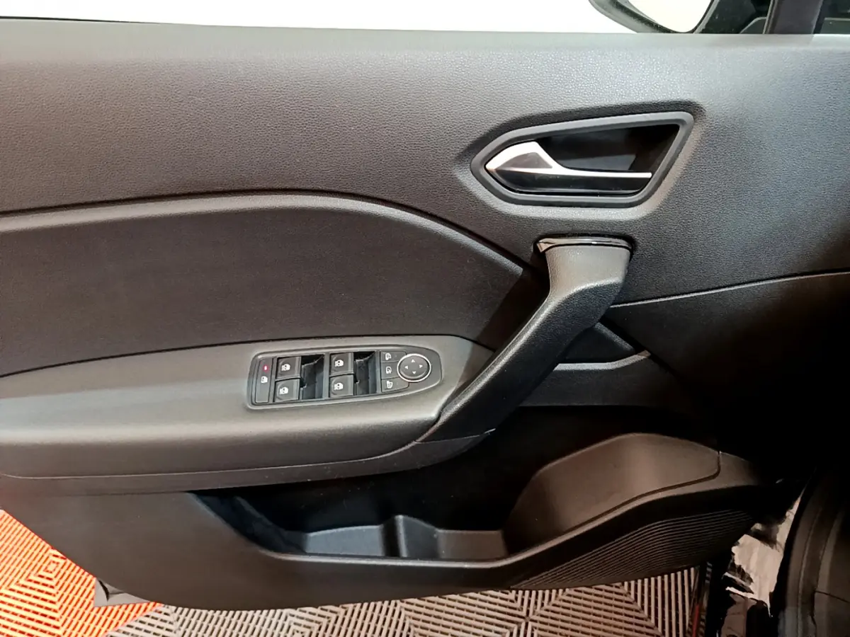 Vue intérieure côté gauche de la porte noire du Renault Captur 2020 avec commandes électriques des vitres et poignée intégrée.