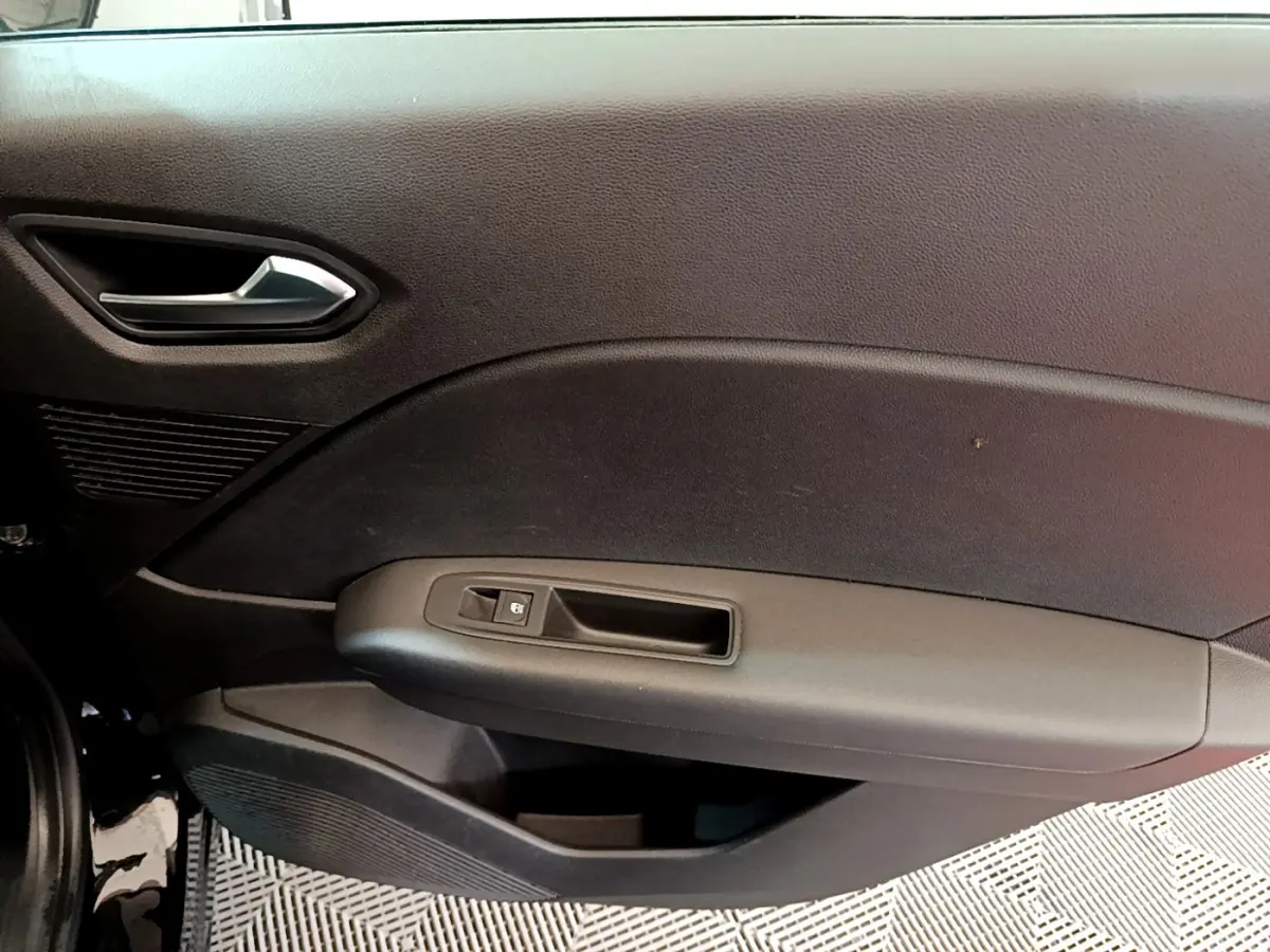 Gros plan sur la porte côté gauche noire du Renault Captur Business 2020, avec poignée argentée et commande de vitre.