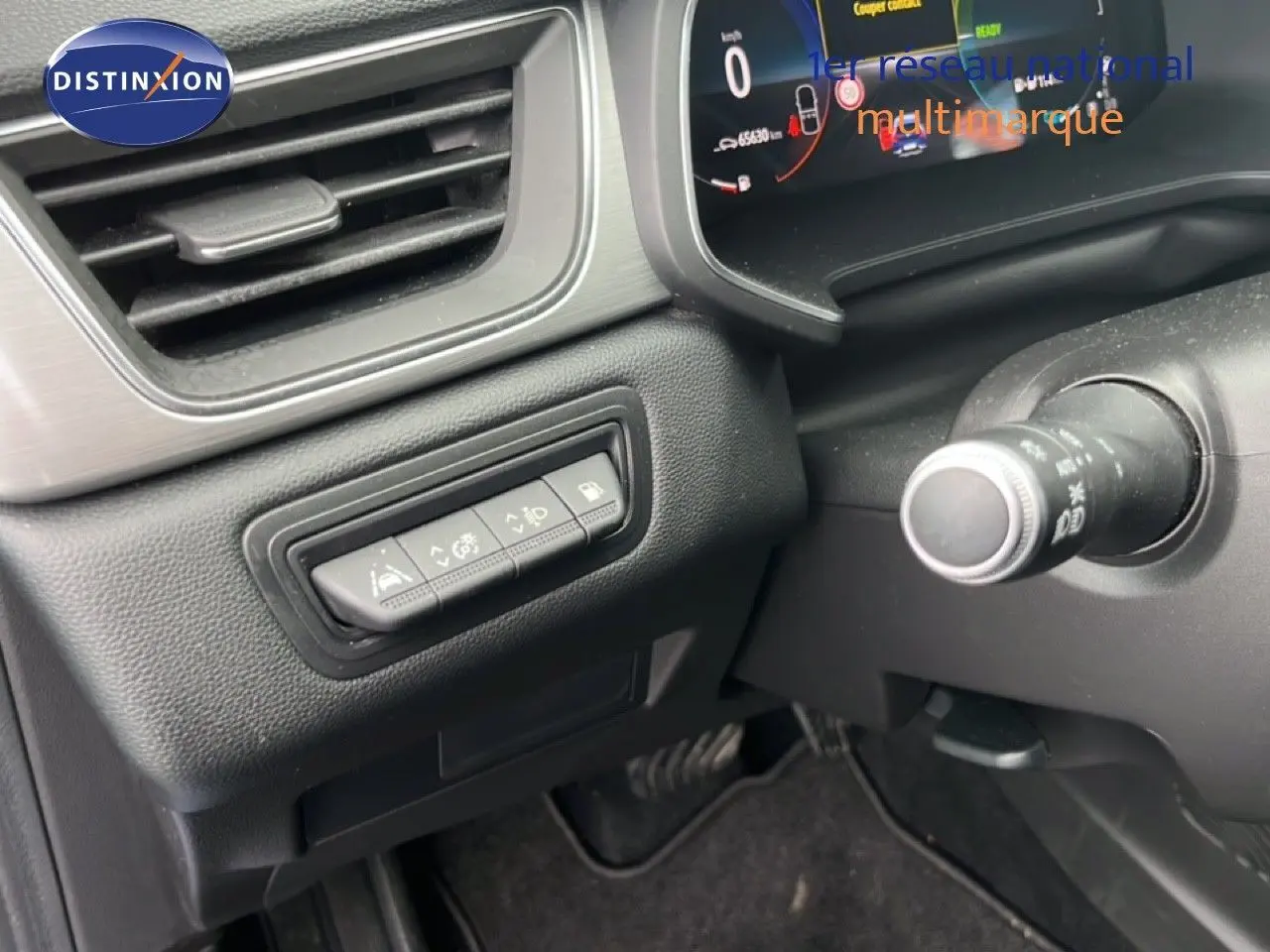 Vue intérieure côté gauche du tableau de bord du Renault Captur bleu iron metal avec toit noir, montrant les commandes d'assistance et l'écran digital.
