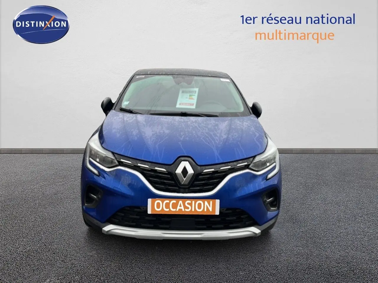 Vue de face du Renault Captur bleu Iron Metal avec toit noir, mettant en valeur la calandre et les phares LED.