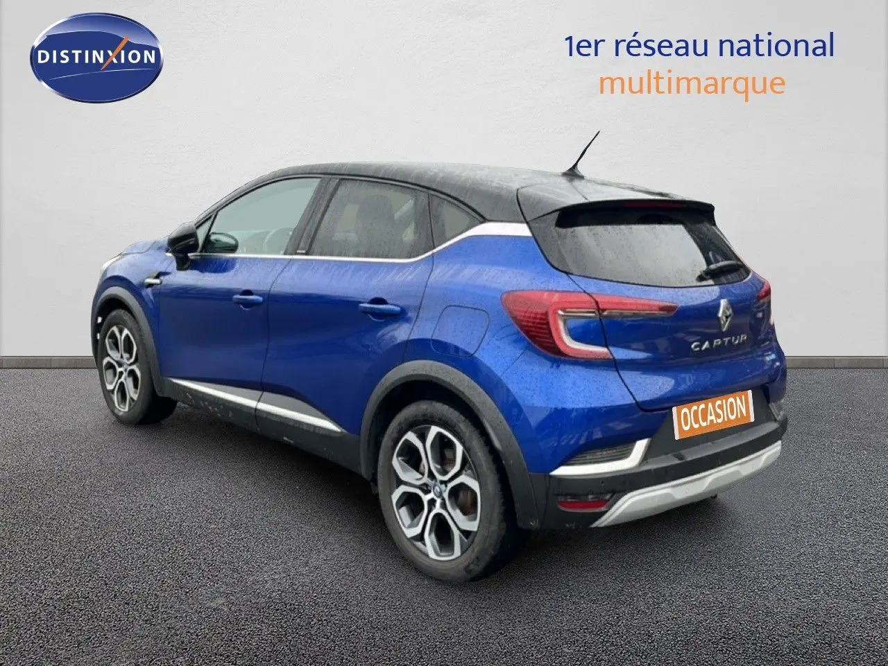 Vue 3/4 arrière droite d’un Renault Captur bleu Iron Metal avec toit noir, roues alliage et feux LED distinctifs.