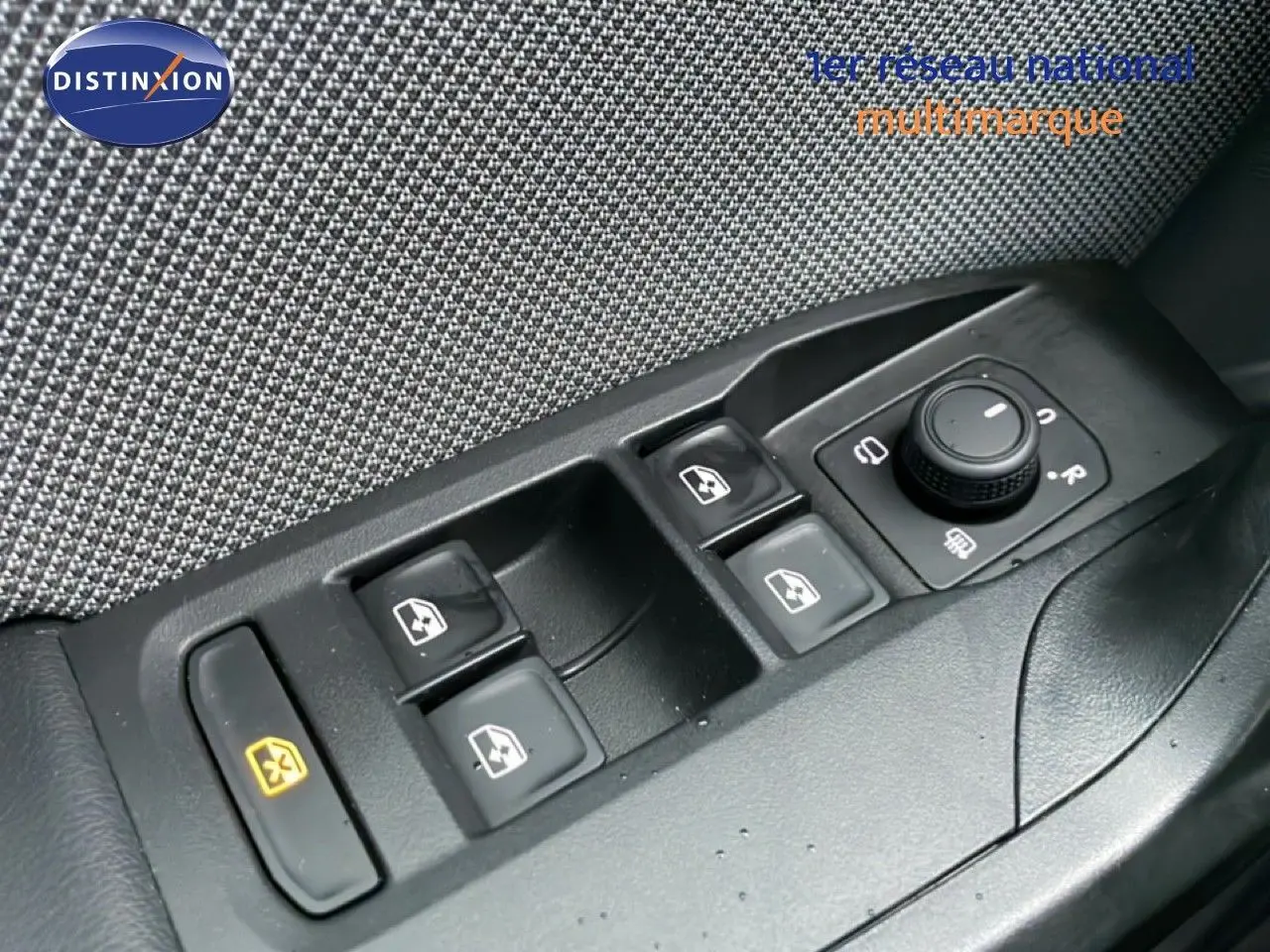 Gros plan sur les commandes de lève-vitres et réglage des rétroviseurs côté conducteur d’un SEAT LEON ST bleu Fjord.