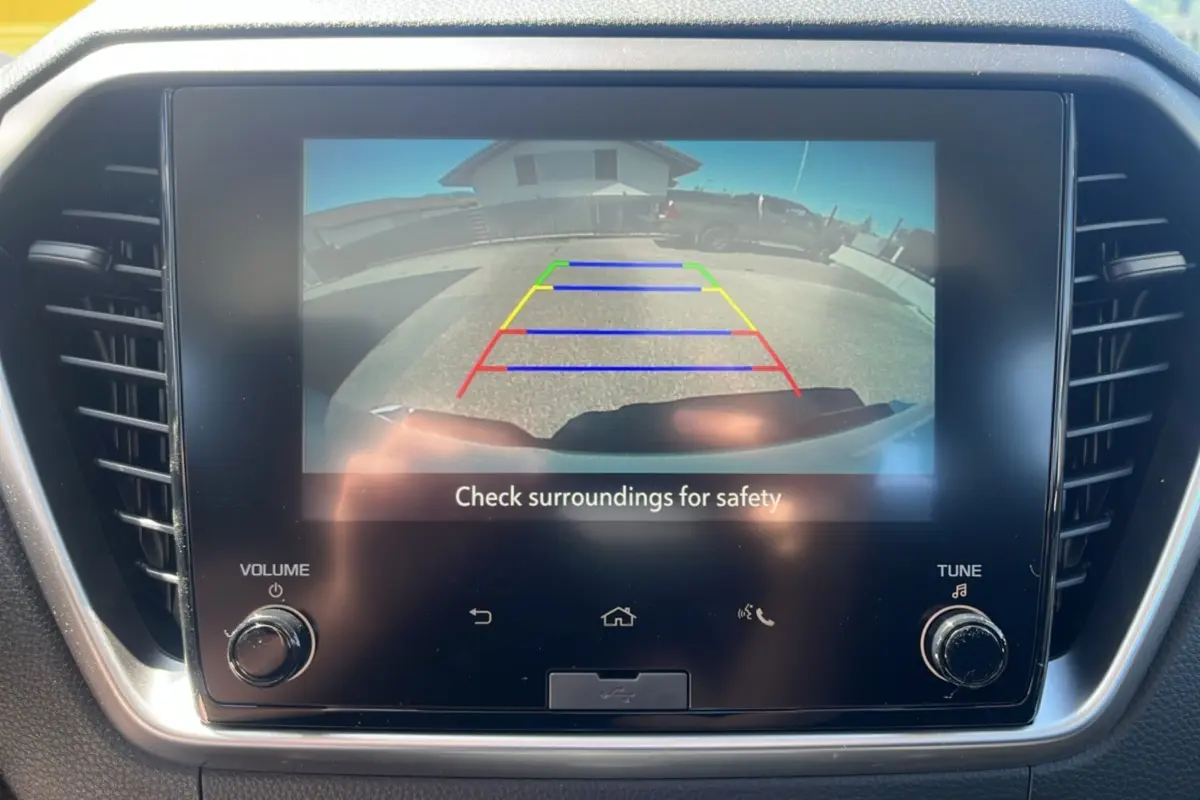Écran tactile intérieur montrant la caméra de recul avec lignes de guidage colorées sur un Isuzu D-MAX blanc.