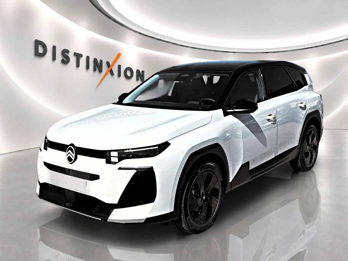 Vue 3/4 avant d'un Citroën C5 Aircross blanc à toit noir, avec jantes alliage noires et calandre distinctive.