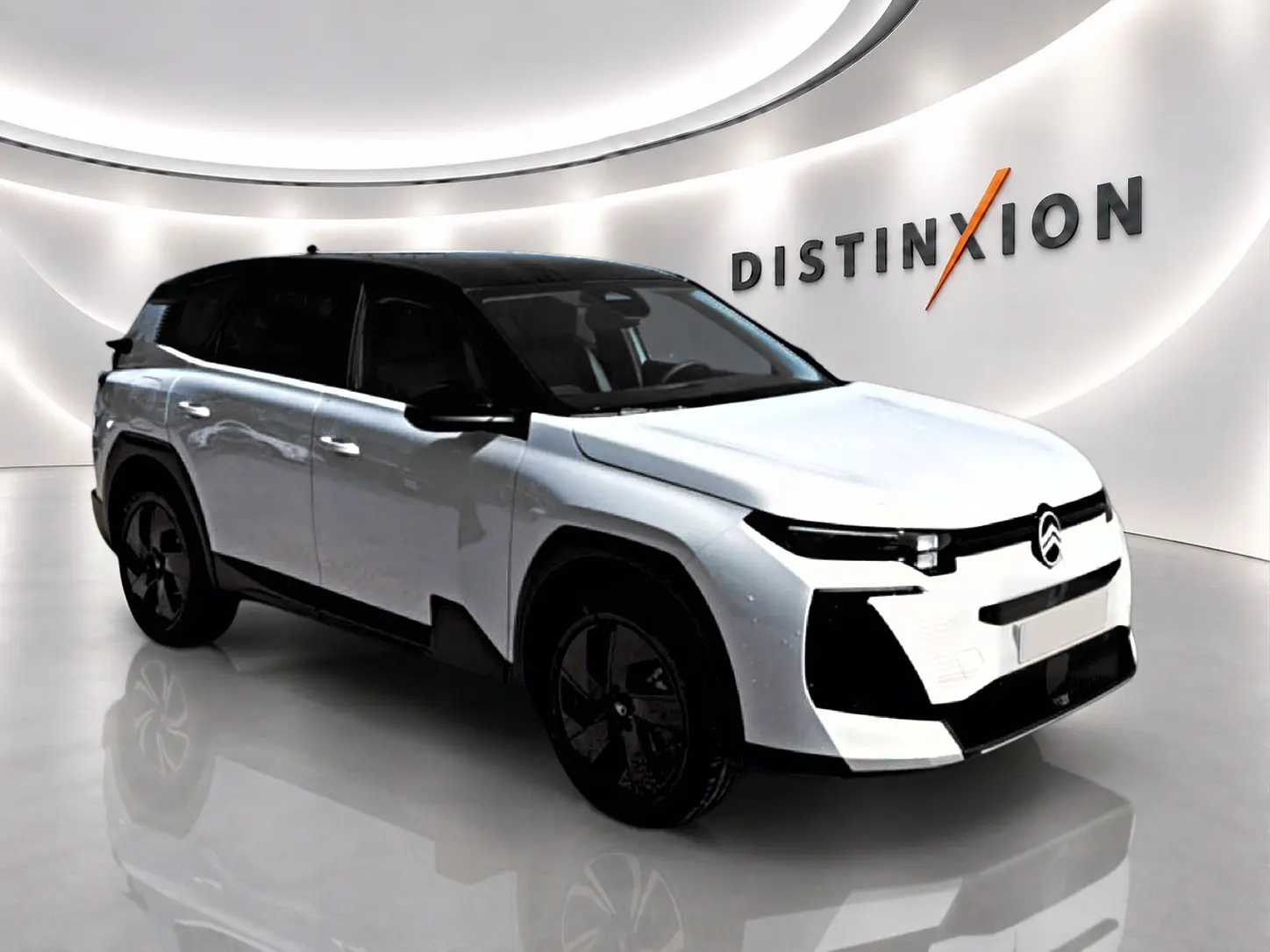 Vue 3/4 avant gauche du Citroën C5 Aircross hybride blanc et noir avec jantes alliage 19 pouces dans un showroom.