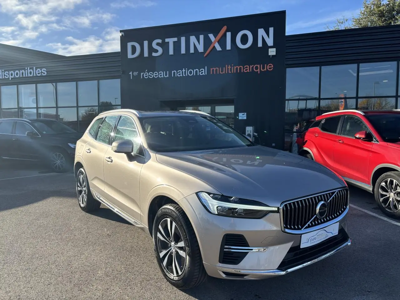 Volvo XC60 T6 Recharge argent crépuscule métal en 3/4 avant, avec calandre verticale et jantes alliage 18 pouces.