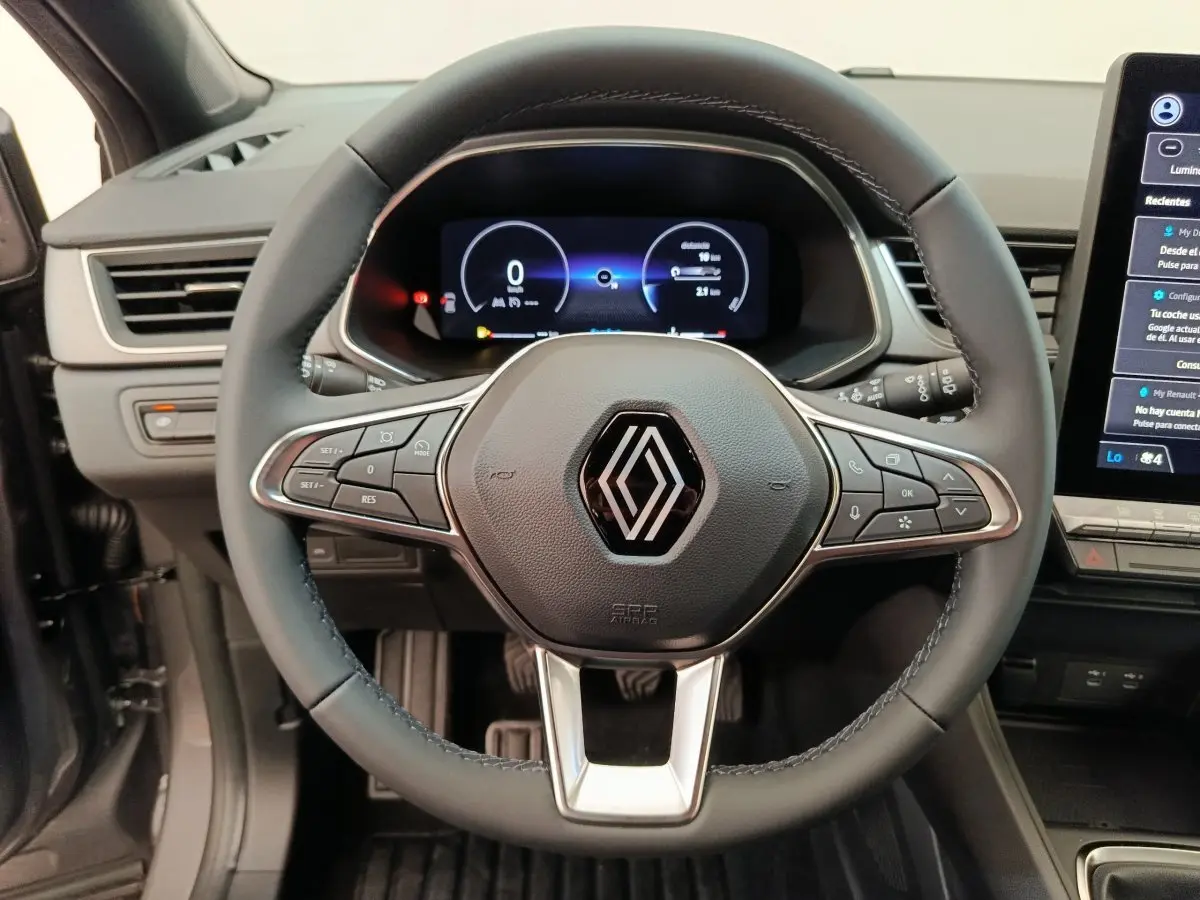 Vue rapprochée du volant noir de la Renault Captur 2025 avec tableau de bord numérique et écran tactile latéral.