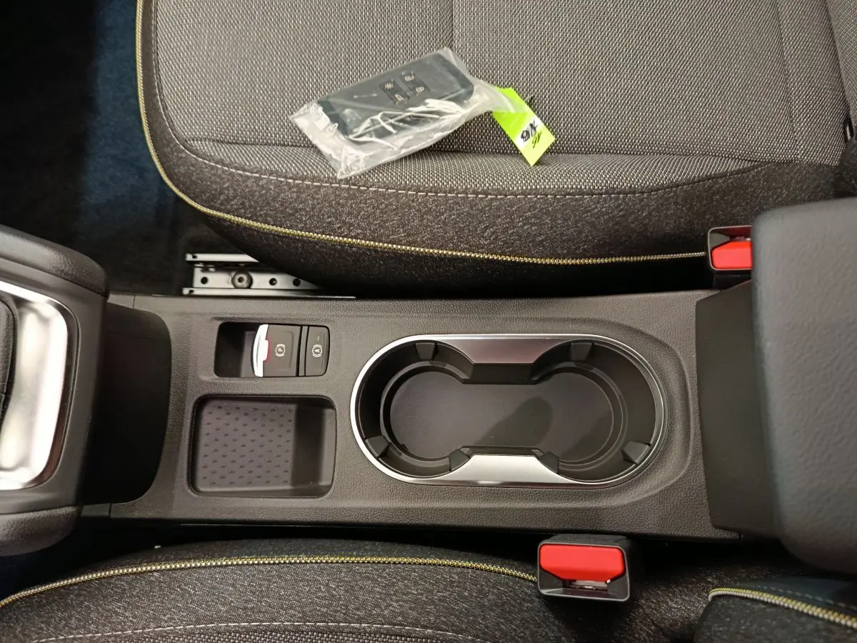 Vue plongeante sur la console centrale noire avec porte-gobelets et sièges gris foncé du Renault Captur 2025 Techno Eco-G.