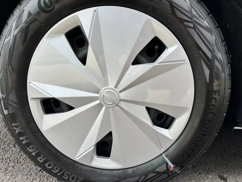 Gros plan sur la jante avec enjoliveur argenté et logo Nissan au centre du Nissan Townstar électrique gris 2024.