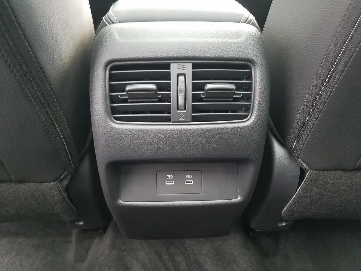 Vue rapprochée de la console arrière noire du Nissan Qashqai 2025 avec deux bouches d’aération et ports USB-C.