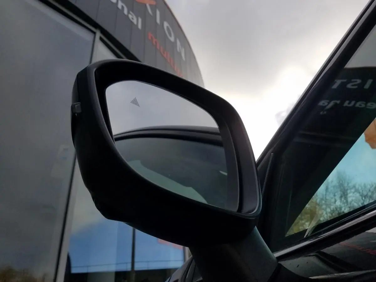 Rétroviseur extérieur droit noir du Nissan Qashqai 1.5 E-POWER 190 Connecta avec toit panoramique visible en reflet.