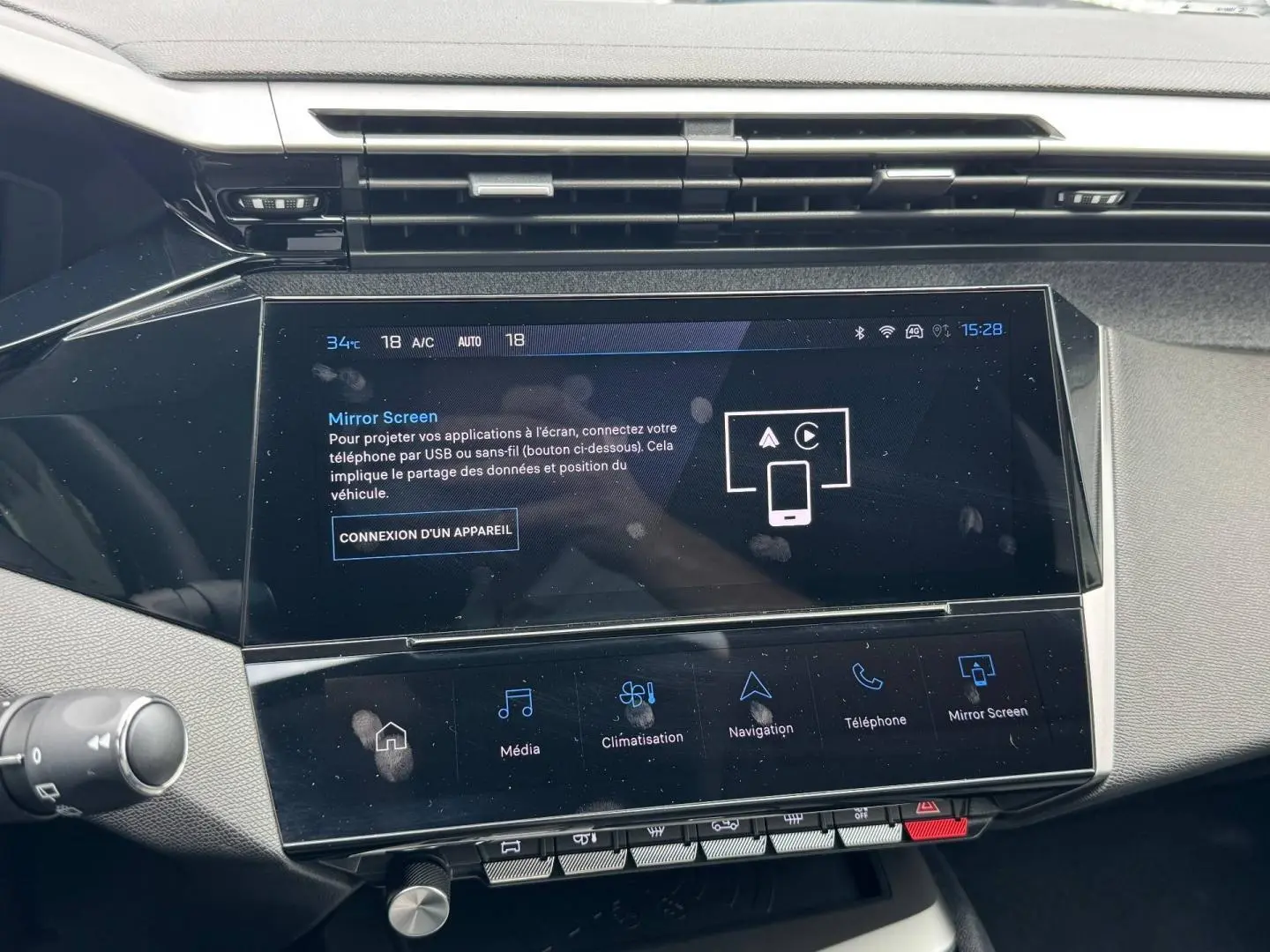 Vue rapprochée de l’écran tactile central du tableau de bord de la Peugeot 308 1.2 Hybrid 2025, affichant le menu Mirror Screen.