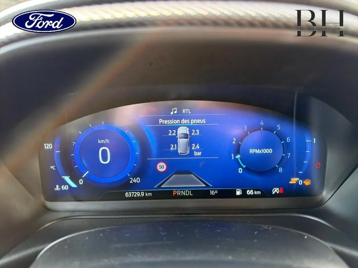 Tableau de bord numérique du Ford Puma 2023 montrant la pression des pneus et compte-tours en bleu lumineux.
