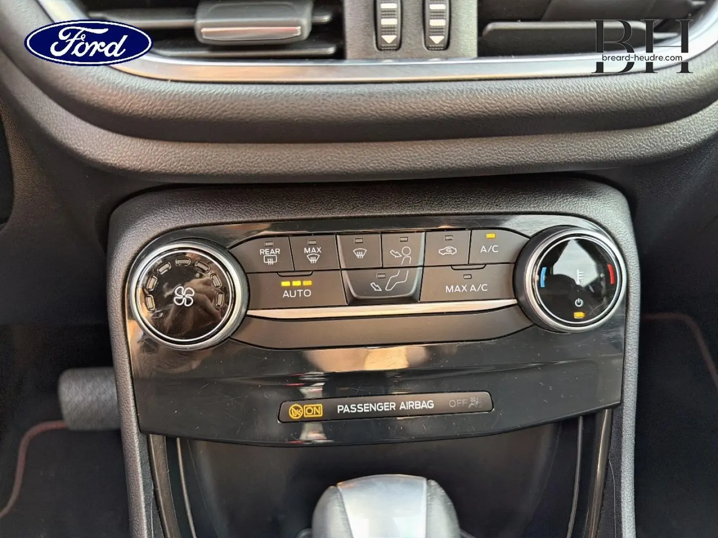 Gros plan sur la console centrale noire du Ford Puma 2023, montrant les commandes de climatisation et la boîte automatique.