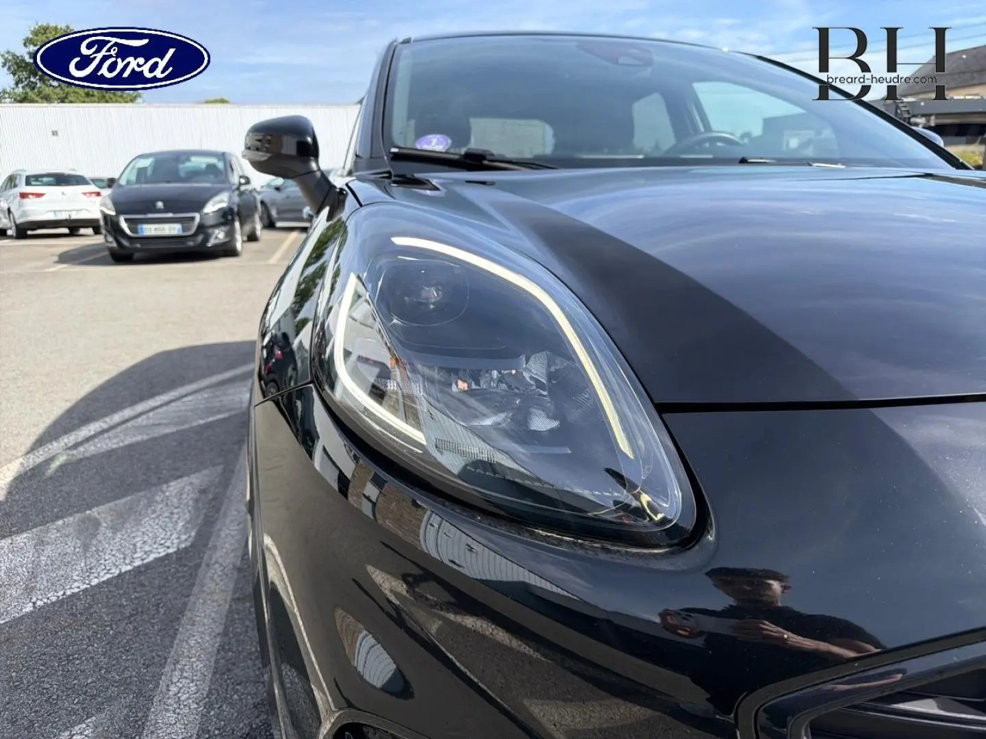 Gros plan sur le phare avant gauche du Ford Puma 2023 noir Agate Métallisée, mettant en valeur son design moderne et lumineux.
