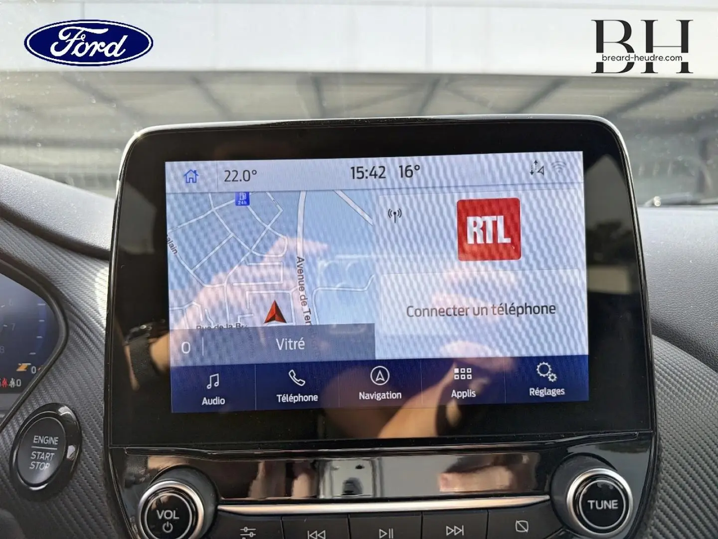 Écran tactile central du Ford Puma 2023 affichant la navigation et les options multimédia, avec bouton start/stop visible.