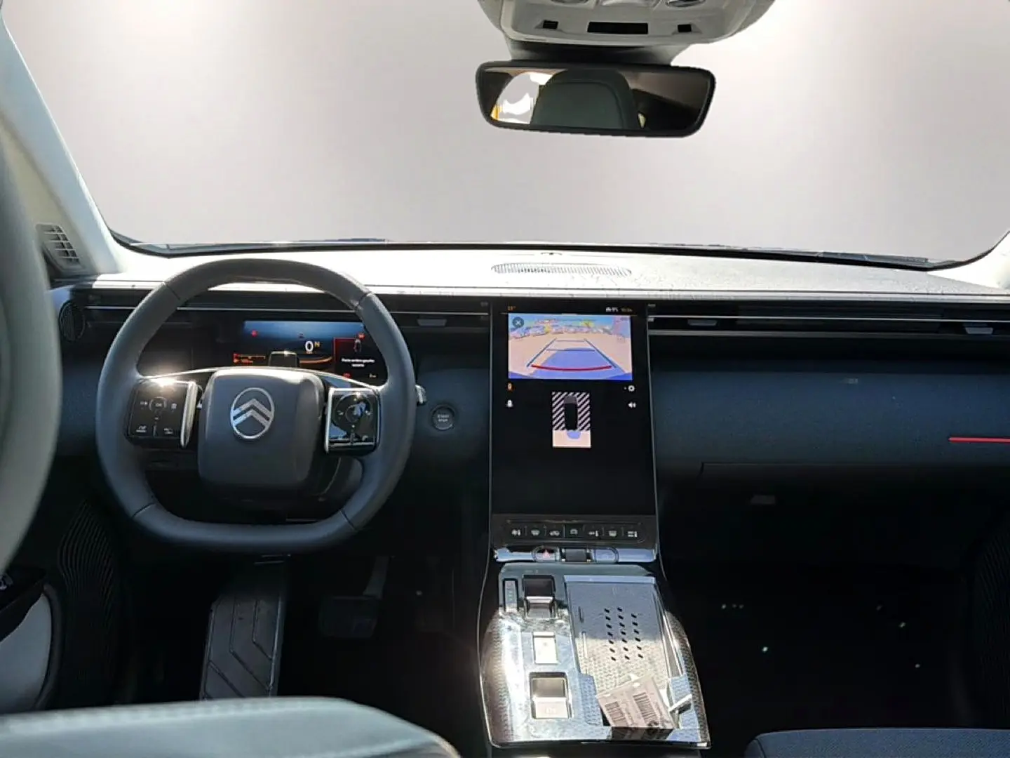 Vue intérieure avant du Citroën C5 Aircross hybride 2026, tableau de bord noir avec écran tactile central affichant la caméra de recul.