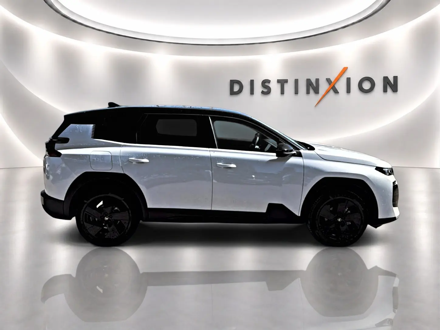 Vue de profil droit du Citroën C5 Aircross blanc avec toit noir et jantes alliage noires dans un showroom lumineux.