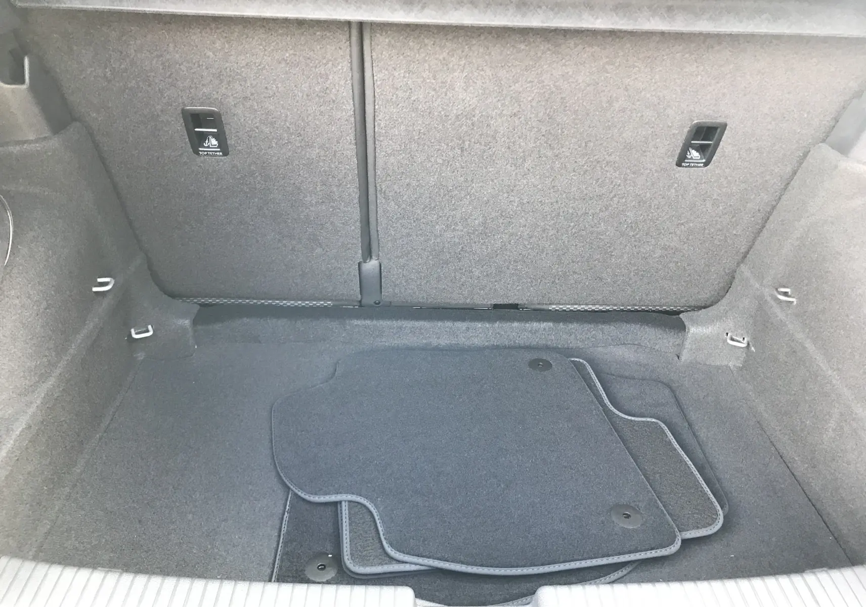 Vue intérieure du coffre gris clair du Volkswagen T-Cross 2020, avec tapis de sol noirs posés à plat.