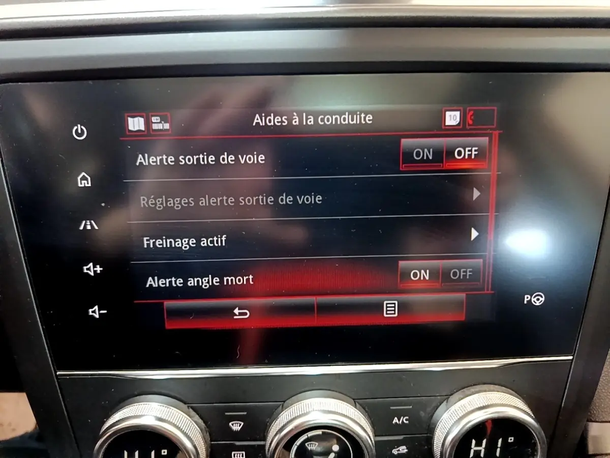 Écran tactile central du Renault Kadjar Rouge 2019 affichant les aides à la conduite, avec commandes climatisation en dessous.