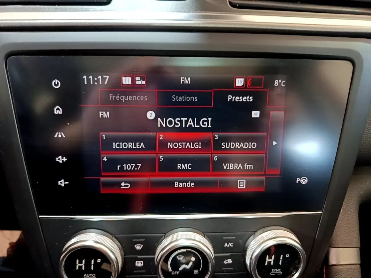Écran tactile central affichant les stations radio FM dans un Renault Kadjar rouge, vue intérieure frontale.