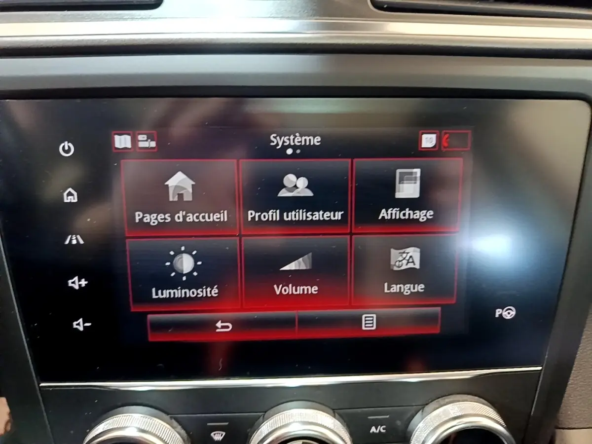 Écran tactile central du Renault Kadjar rouge, affichant le menu système avec options luminosité, volume et langue.