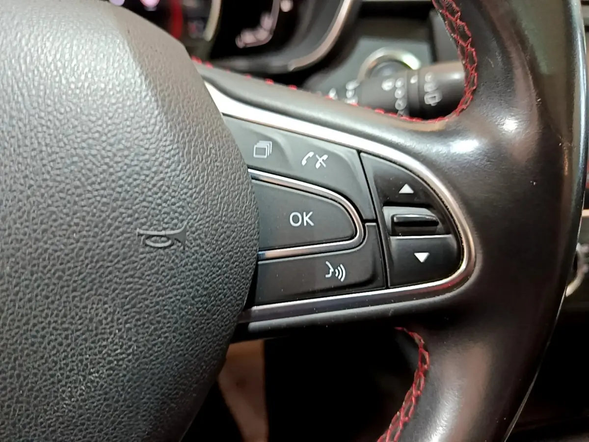 Gros plan sur le côté droit du volant cuir noir avec surpiqûres rouges du Renault Kadjar 2019.