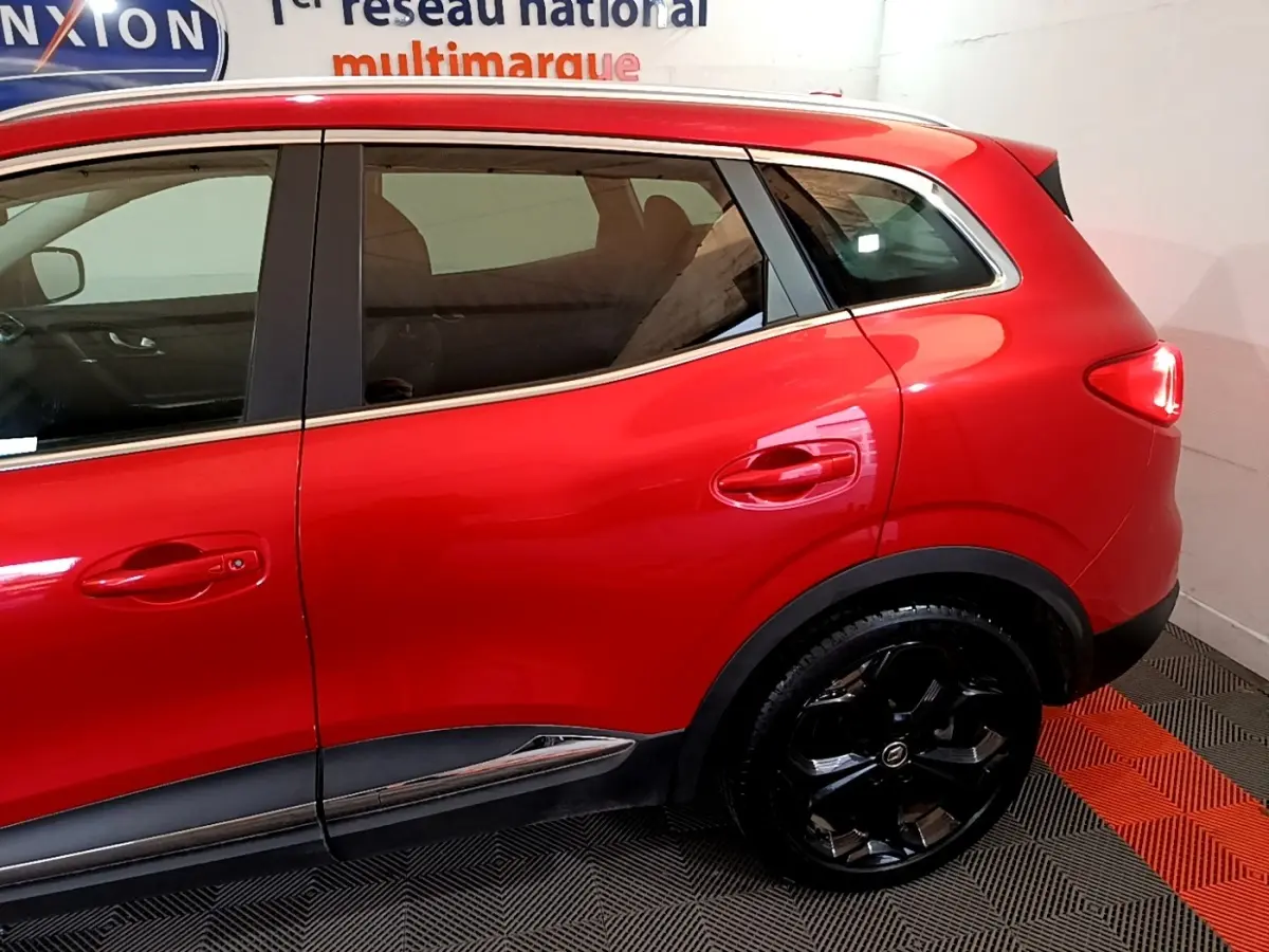 Vue côté droit arrière du Renault Kadjar SL Black Edition rouge avec jantes noires brillantes et poignées de porte ton caisse.