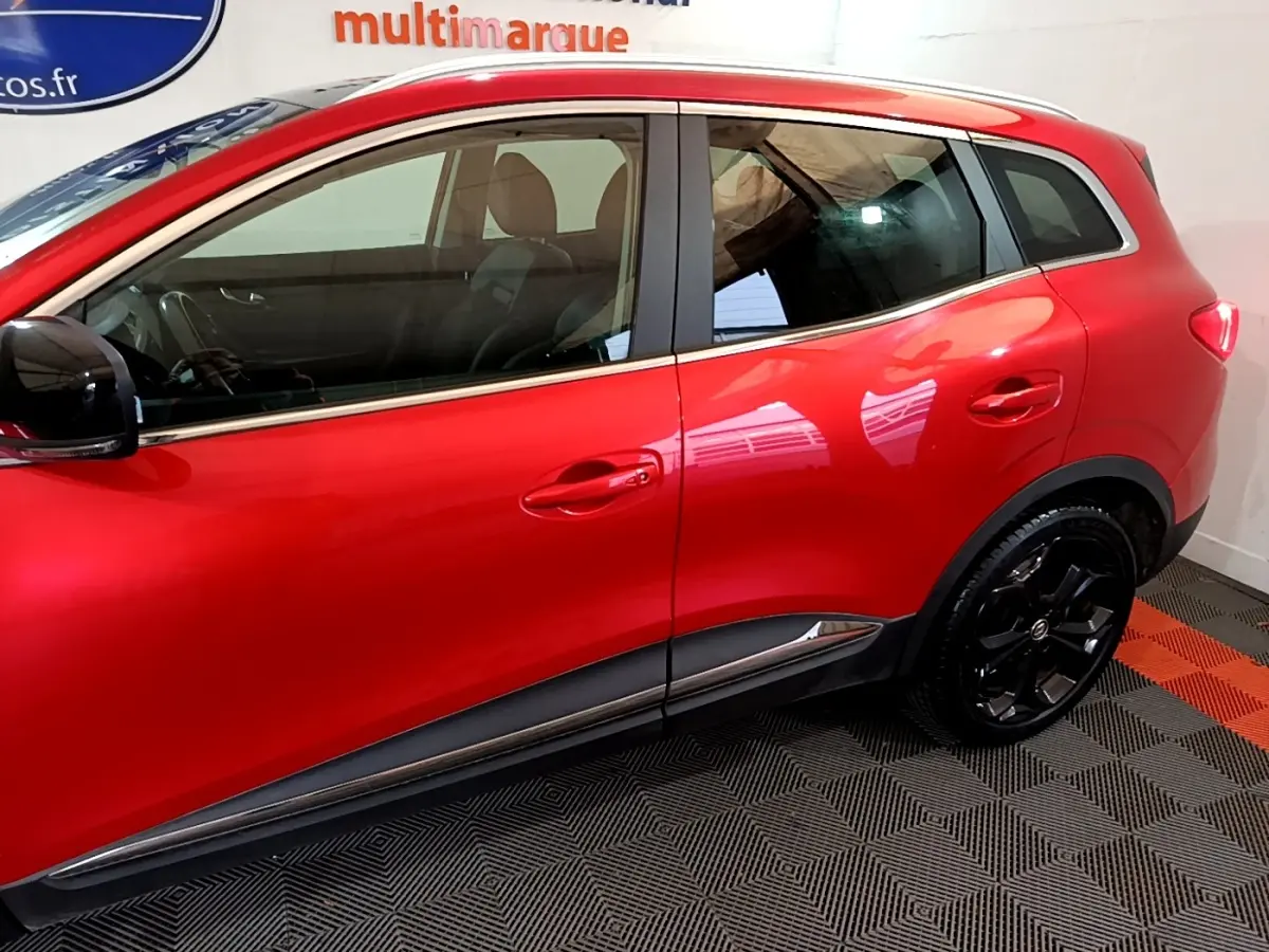 Profil côté gauche du Renault Kadjar SL Black Edition rouge, soulignant les jantes noires et la ligne de caisse chromée.