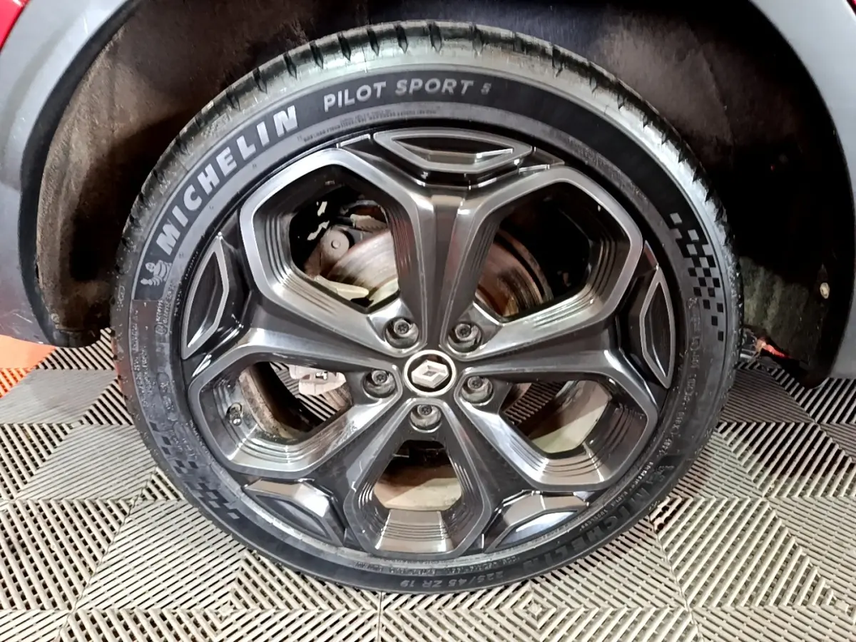 Gros plan sur la roue arrière droite du Renault Kadjar rouge, montrant le pneu et l'arche de roue intérieure.