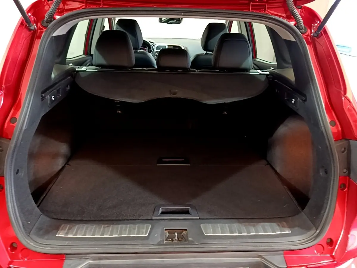 Vue arrière du coffre ouvert du Renault Kadjar rouge, montrant l'espace de chargement et la banquette arrière noire.