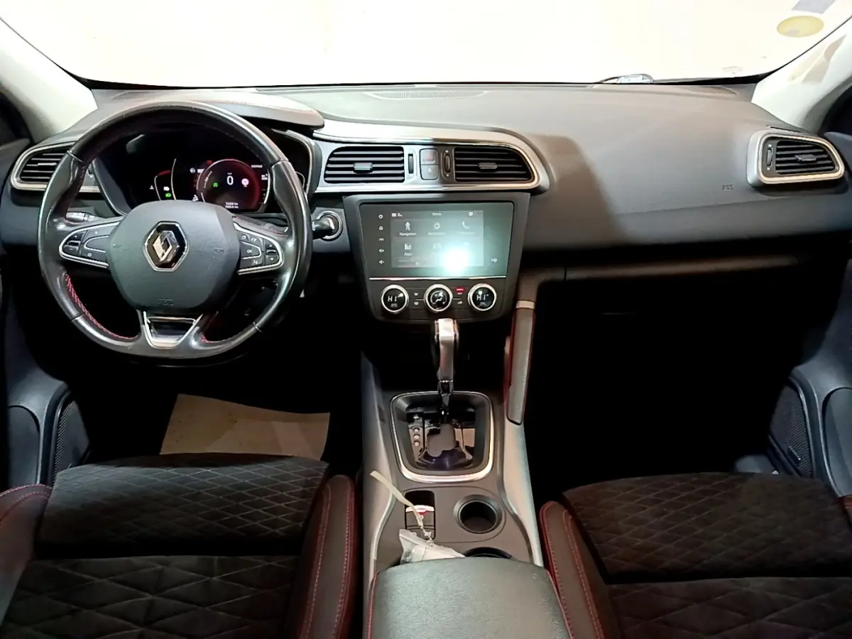 Vue intérieure avant du Renault Kadjar SL Black Edition avec tableau de bord noir, volant cuir et écran tactile central allumé.
