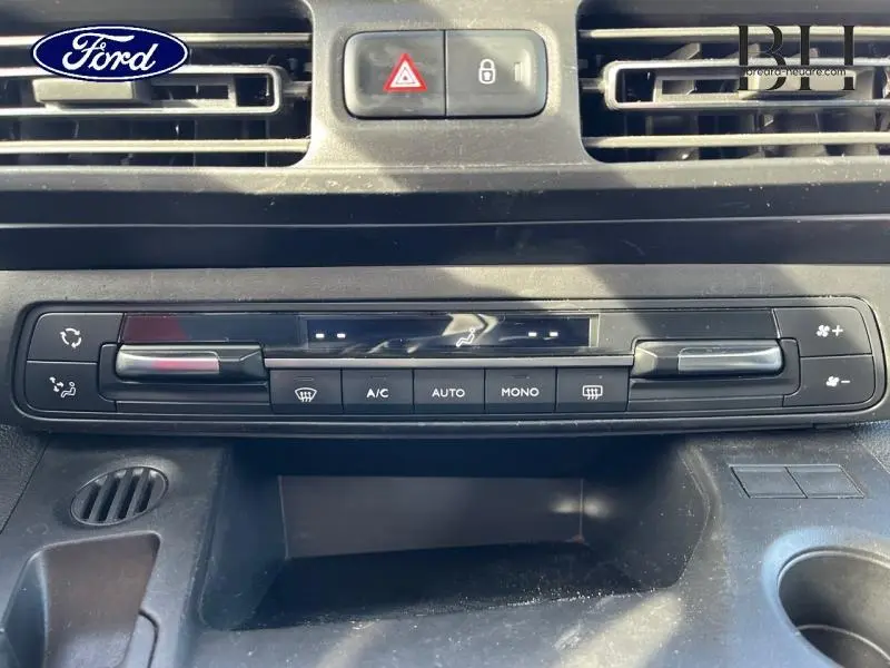 Panneau de commande de climatisation noir vu de face dans un véhicule, avec boutons et curseurs de réglage.