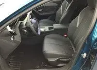 Vue intérieure côté conducteur de la Peugeot 308 Bleu Obsession 2025, mettant en valeur les sièges et le tableau de bord moderne.