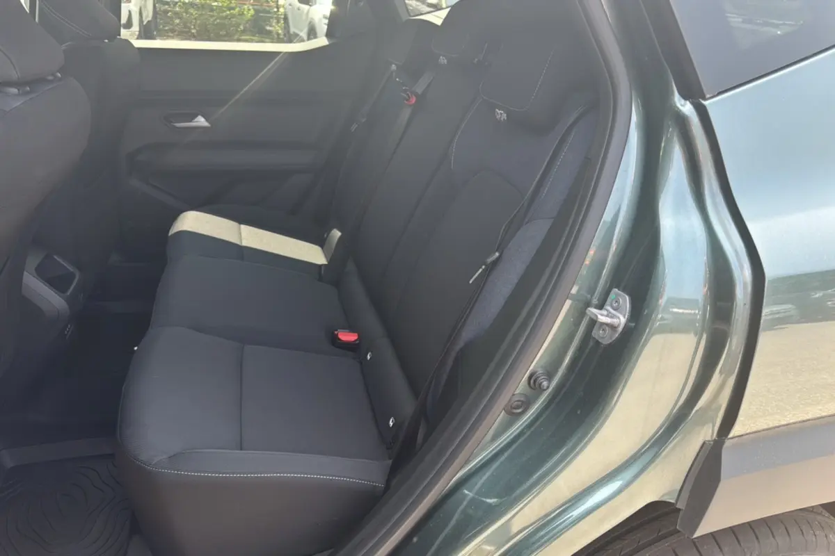 Vue côté droit sur la banquette arrière noire du Dacia Duster 2025 vert cèdre avec porte ouverte.