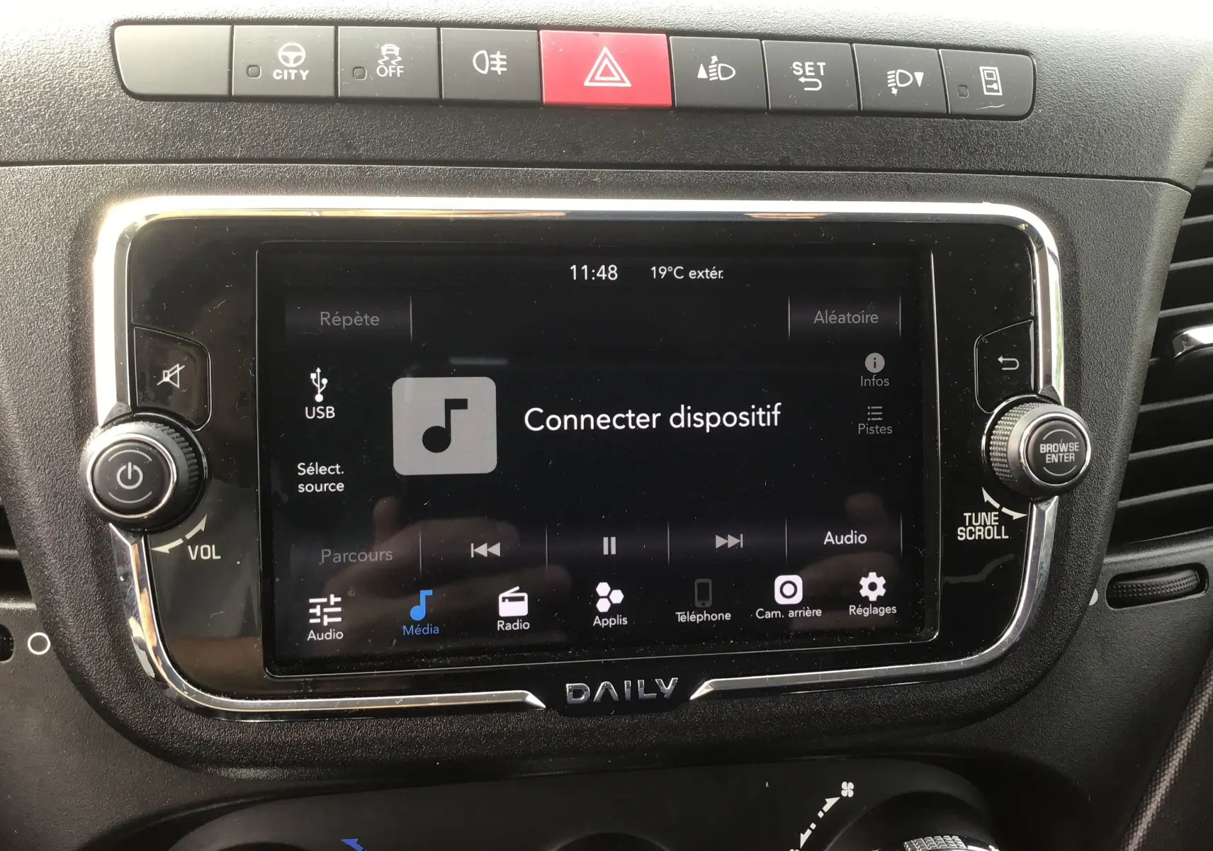 Écran tactile central du tableau de bord du Iveco Daily Chassis Cabine blanc, avec commandes multimédia et climatisation visibles.