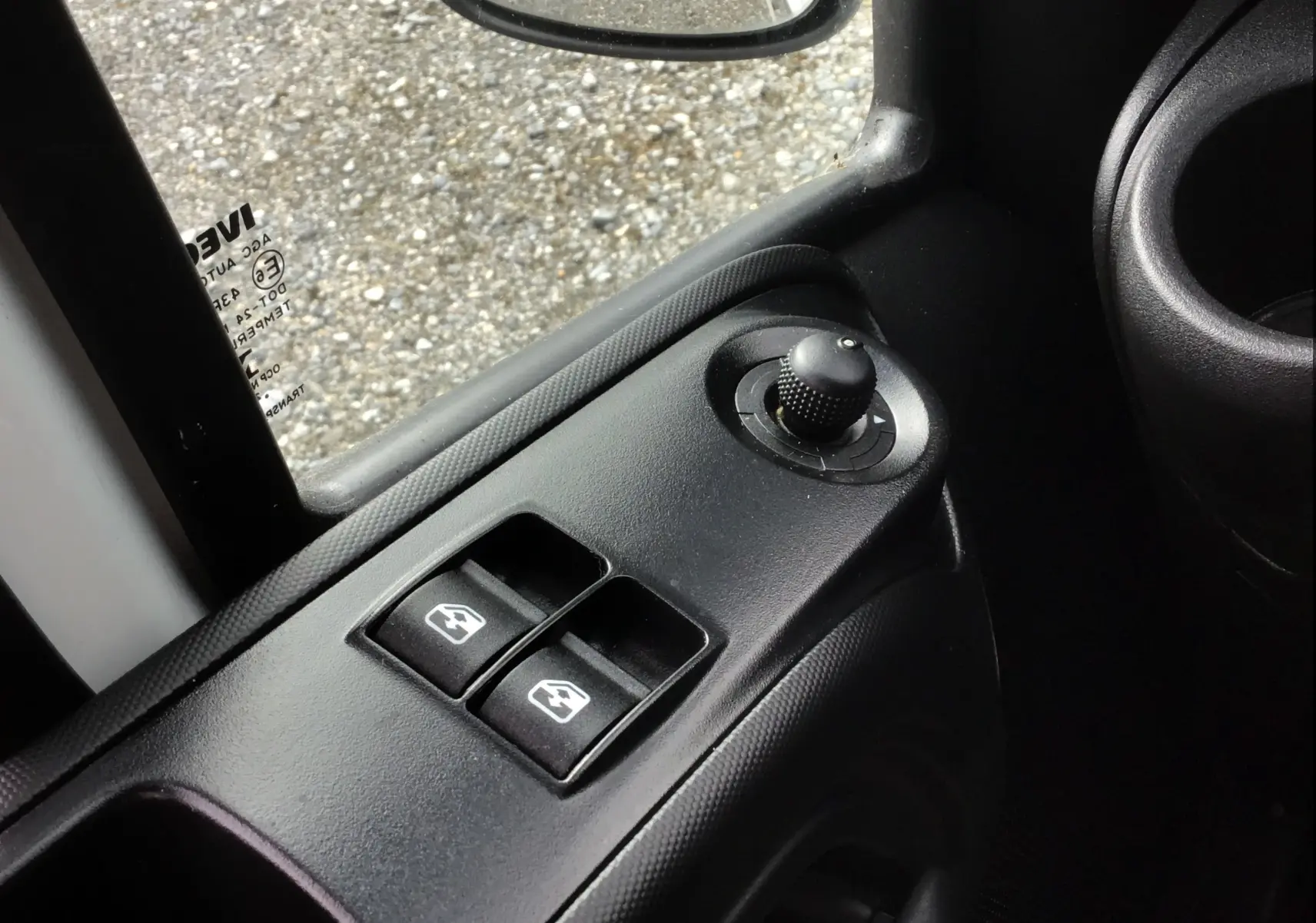 Gros plan sur les commandes électriques de vitres et rétroviseurs côté conducteur du camion blanc Iveco Daily Chassis Cabine 2022.