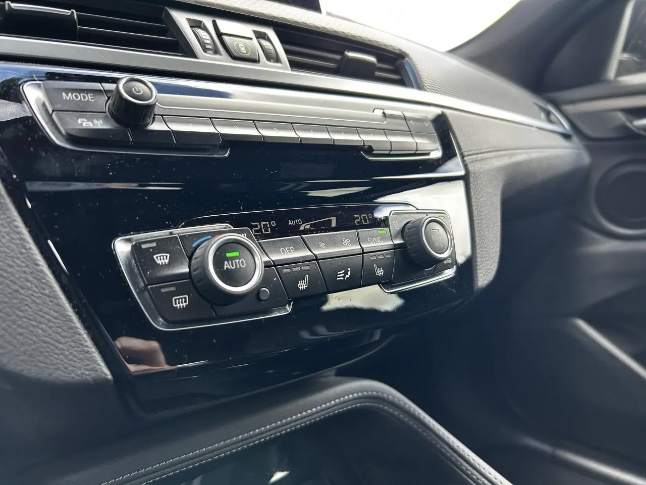 Détail du tableau de bord noir brillant avec commandes de climatisation automatique sur BMW X2 F39 2021.