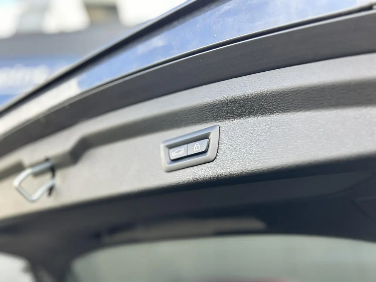 Bouton de fermeture électrique du hayon sur BMW X2 gris Mineral, vue rapprochée du hayon ouvert.