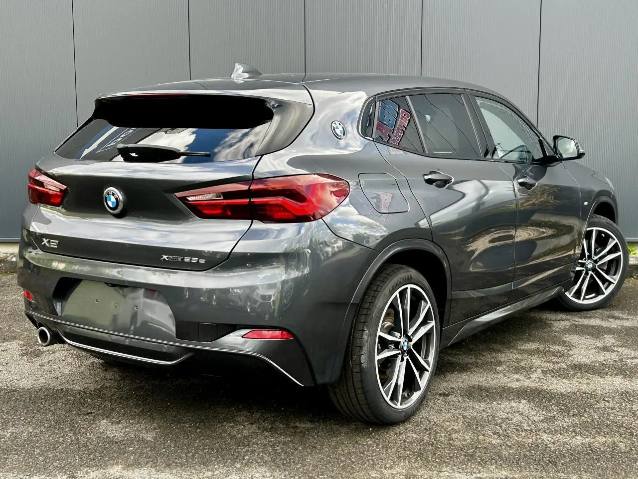 BMW X2 F39 xDrive 25e gris Mineral vue 3/4 arrière droit avec jantes alliage bicolores et hayon fermé