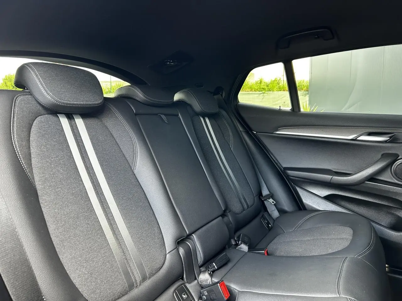 Vue intérieure côté droit des sièges arrière en tissu et cuir noir du BMW X2 F39 M Sport 2021.