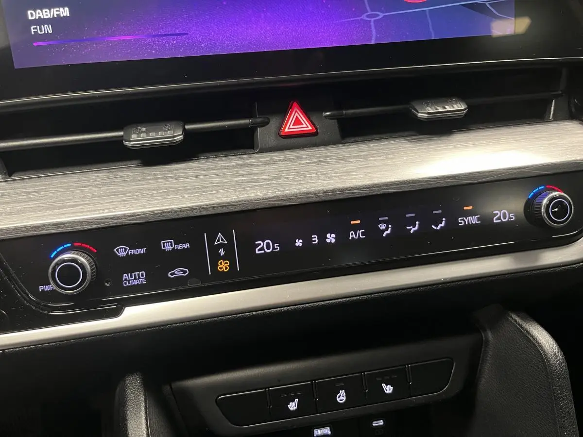 Tableau de bord du Kia Sportage 2022, affichage digital de la climatisation et commandes de sièges chauffants.