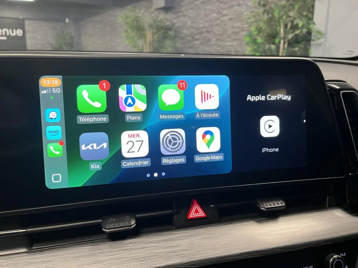 Écran tactile 12,3 pouces du Kia Sportage blanc 2022 affichant Apple CarPlay et applications connectées.