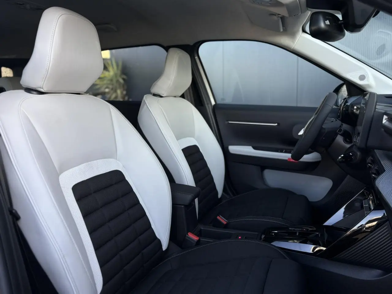 Vue intérieure côté droit du Citroën C3 Aircross 2025 avec sièges bicolores blanc et noir et tableau de bord moderne.