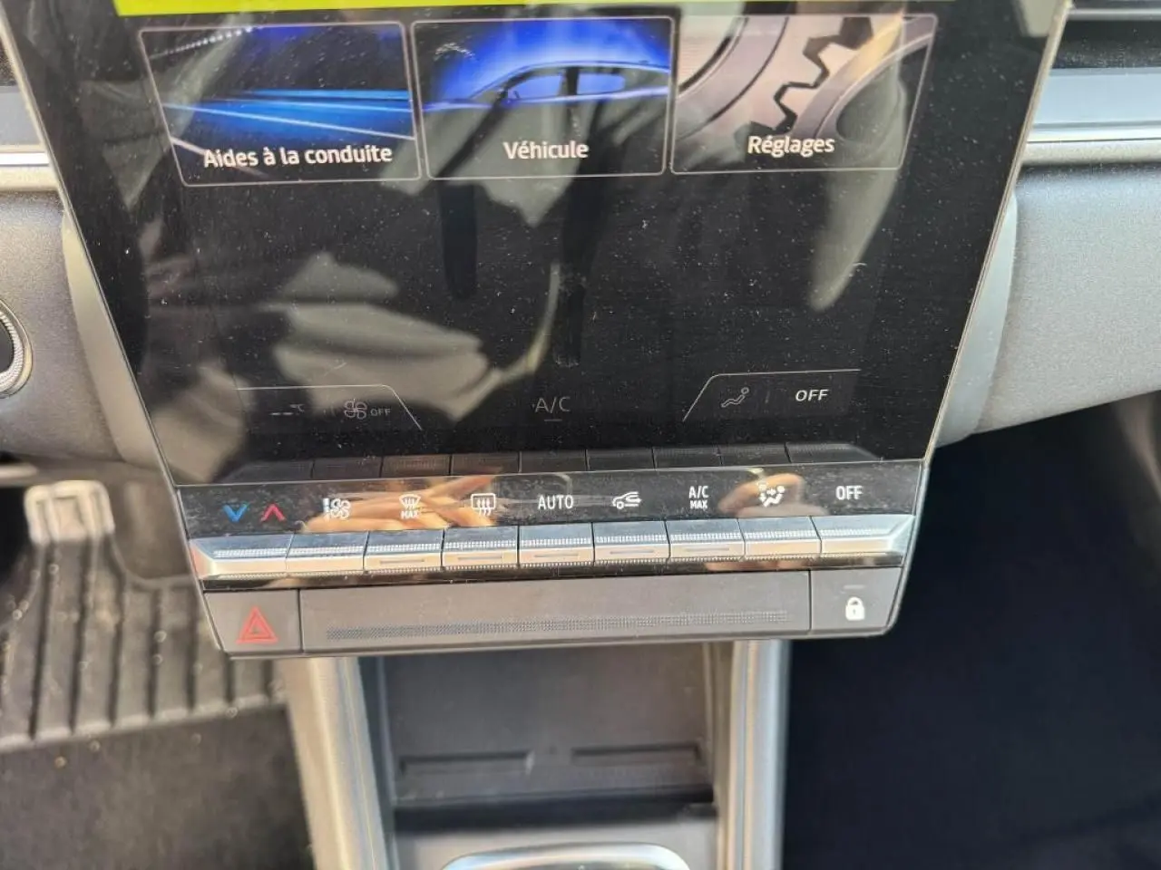 Vue rapprochée du tableau de bord numérique et des commandes tactiles de climatisation du Renault Captur II rouge flamme.