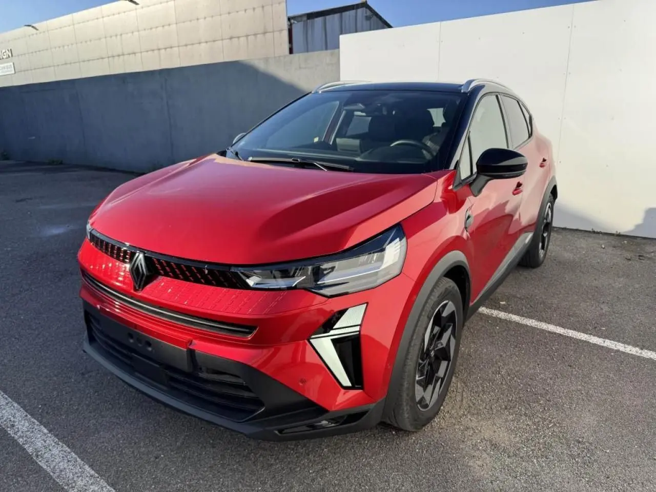 Renault Captur II rouge flamme avec toit noir, vue 3/4 avant droit, jantes aluminium et signature lumineuse LED.