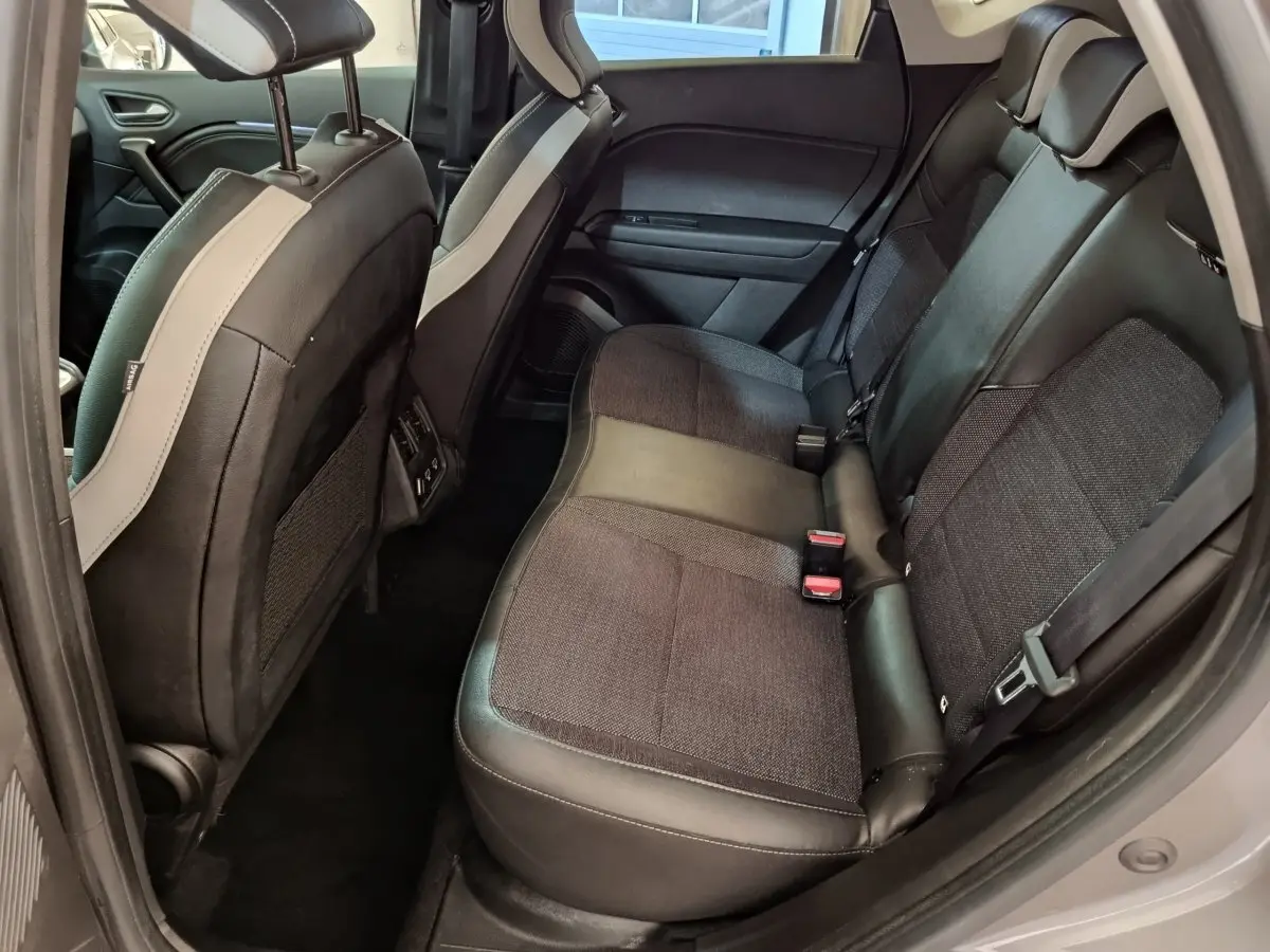 Vue côté droit de la banquette arrière noire et grise du Renault Captur Techno TCe 90 2024, intérieur spacieux et moderne.