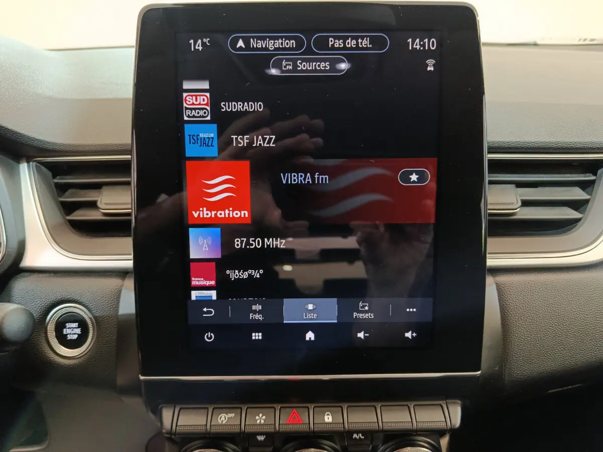 Vue rapprochée de l'écran tactile central du tableau de bord du Renault Captur Techno TCe 90 gris foncé, avec bouton démarrage visible.