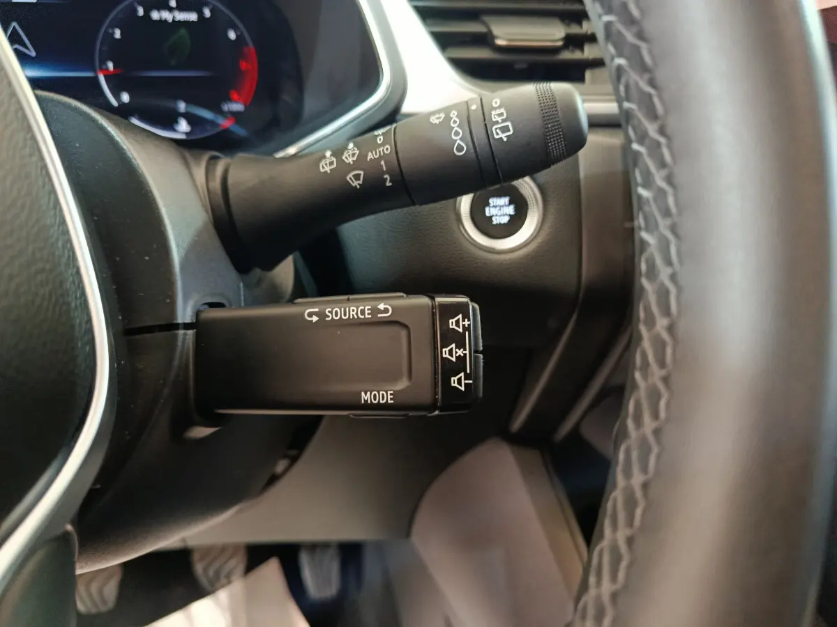 Gros plan sur la commande multifonction et bouton démarrage du tableau de bord du Renault Captur gris foncé 2024.