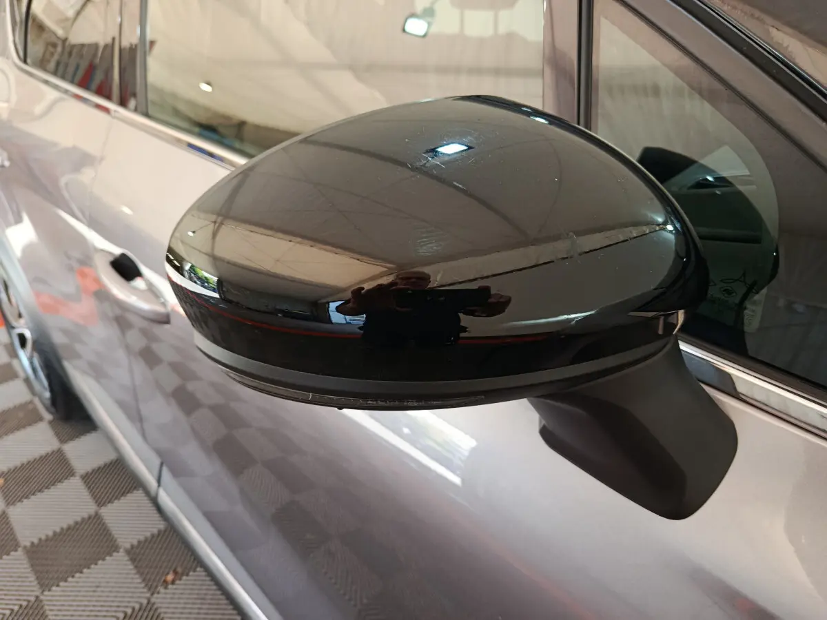 Rétroviseur noir côté gauche en gros plan sur Renault Captur gris foncé vue latérale intérieure.